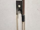 a violin bow and a bow rest on a white surface
