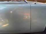 a silver car parked in a parking lot next to a fence