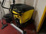 a yellow and black vacuum and a black bucket on a red floor