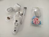 a white electric shaver sitting on a table next to other items