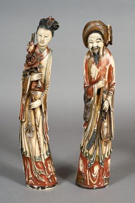 two asian figurines of a woman and a man holding a child