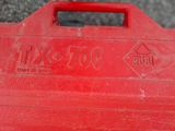 an old red tool box sitting on top of a cement floor