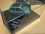 une petite voiture bleue dans une vitrine posée sur une table