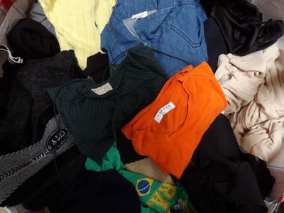 a lot of clothes in a suitcase that is full of them