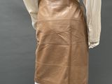 an image of a mannequin wearing a tan skirt and white shirt