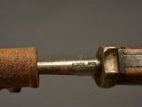 close up of a metal tool with a rusted handle on a gray background