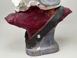 a ceramic sculpture of a woman with a hat on her head