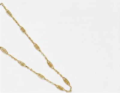 un collier plaqué or composé d'une longue chaîne ornée d'un motif de feuilles