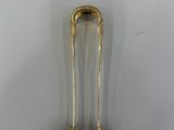 a gold colored hair pin on a white background