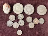 some coins are sitting on a red cloth with a coin in front of them