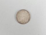 a close up of a coin on a white surface with a white background