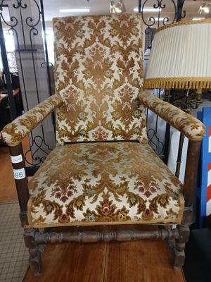 a chair that is sitting in a room with a lamp on it