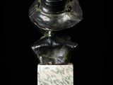 bronze bust of a woman with a hat on top of a marble block