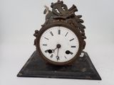 une horloge posée sur un support sur une surface blanche