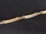 bracelet made of silver and gold metal with a clasp on a black background
