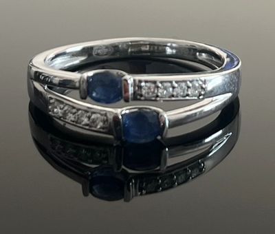 a close up of a ring with sapphires and diamonds