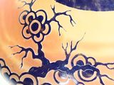 a close up of a vase with a tree on it