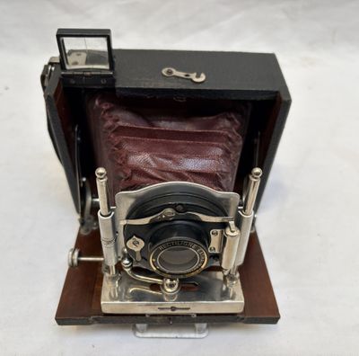 an old camera sitting on top of a wooden stand