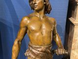 a statue of a man holding a sword and a fish