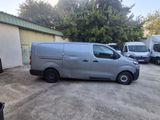 a grey van parked in a parking lot next to a building