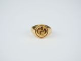 a close up of a gold ring on a white surface