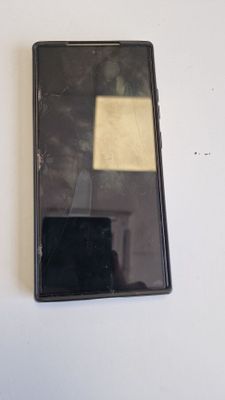 a broken cell phone sitting on a white table