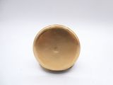 a small gold object on a white surface