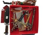 une boîte rouge remplie d'objets divers posée sur une surface blanche