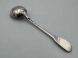 silver spoon with a spoon handle on a gray surface