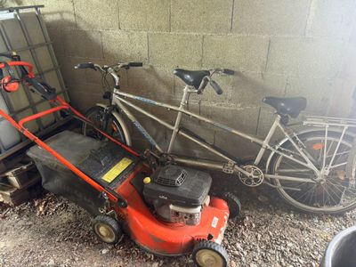 un vélo et une tondeuse à côté d'un vélo