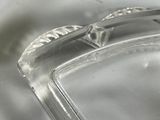 a glass ashtray on a table with a white table cloth