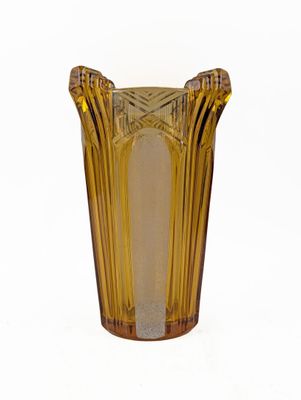 un vase en verre jaune orné d'un motif décoratif