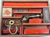 a wooden box with a pair of scissors and other items in it