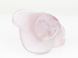 pink flower shaped glass candle holder on a white surface