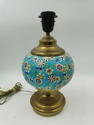 une lampe bleue avec un pied doré orné d'un motif floral