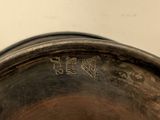 a metal bowl with writing on it sitting on a table