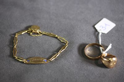 pair of gold rings and a gold bracelet on a gray surface