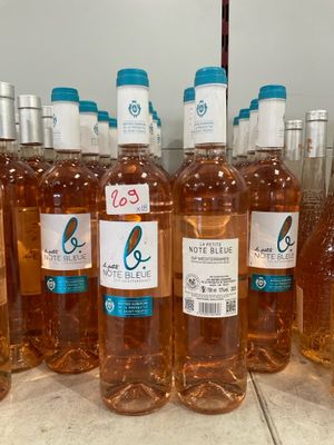 Plusieurs bouteilles de vin rosé sont alignées sur un comptoir