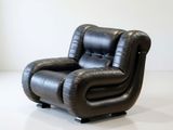 a black leather recliner chair sitting on a white floor