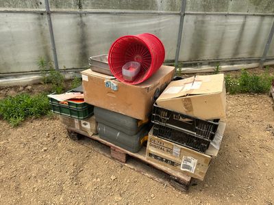 une pile de cartons et un ventilateur posé sur une palette