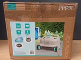 packaging of a robotic lawn mower in a cardboard box on a table