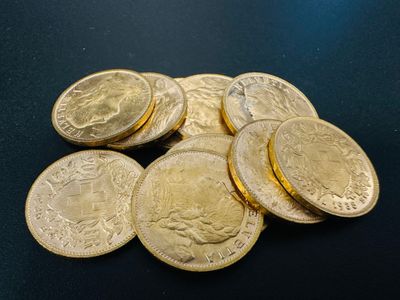 a close up of a pile of gold coins on a black surface