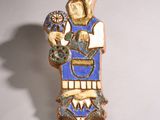 une petite statue représentant une femme tenant une fleur à la main