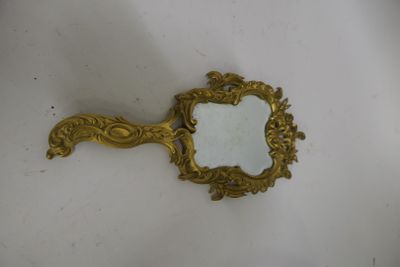 un miroir ancien avec un cadre doré posé sur un fond blanc