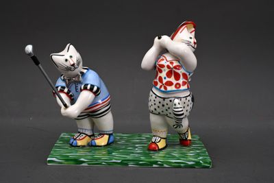 deux figurines représentant un chat et un chat jouant au golf