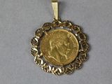 a close up of a gold coin with a chain around it