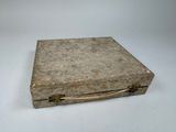 an old box with a handle on a white surface
