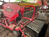 un tracteur rouge garé sur la terre battue