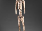 a statue of a skeleton standing on a gray surface