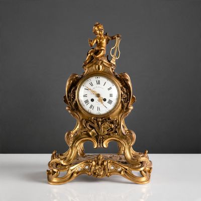 une horloge dorée posée sur une table blanche, sur fond noir